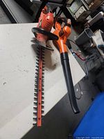Photo of Black & Decker hedge trimmer and leaf blower on white surface.
