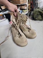 Front and side view of desert tan combat boots size 10.5 men, showing lace-up design and overall condition.