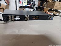 Rear of Extron AV Switcher showing BNC and RCA input/output connectors and power cable attached