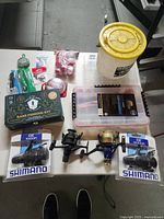 Full lot on table showing fishing reels, kit box, line and bobbers