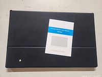 Photo of the closed black protective case with a user manual placed on top, titled 'Portable Monitor User Manual 15.6 inch'.