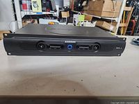 Front view of Samson Servo 200 unit showing front panel with dual channel level meters and sliders. Unit is black with some missing knobs.