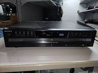 Front view of Sony 5 Disc CD changer showing control buttons, display screen, and model label.