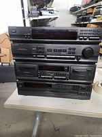 Stack of four Sony audio components on a table, showing front panels with buttons, dials, and displays.