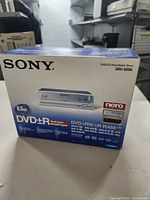 Front and side view of the Sony DVD±RW/CD rewritable drive box showing model DRU-820A and features.
