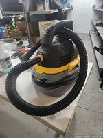 Side view of the Stinger shop vac showing hose and carrying handle.