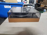 Front view of Thorens turntable with dust cover closed showing wooden plinth