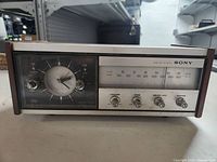 Front view of vintage Sony solid state clock radio showing analog clock, tuning scale, and control knobs.