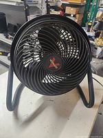 Front view of black Vornado fan showing spiral blade design with visible Vornado logo on the center hub.