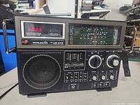Front view of Worldstar MG-6100 multi band radio receiver showing digital frequency display at 92.5, analog tuning scale, speaker grill, control knobs, and switches.