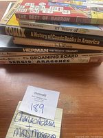 Stack of seven vintage cartoon and humor books, showing titles including 'The Best of Barron,' '27 Years of Shoe,' 'A History of Comic Books in America,' 'Herman Fourth Treasury,' and 'The Groaning Board' by Sergio Aragonés.