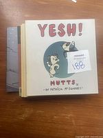 Small collection of Mutts comic books on a wooden surface, showing covers of several issues including 'YESH! Mutts II' by Patrick McDonnell.