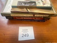 A stack of six books on Toronto history including titles about St. Andrews Church, organs, historical atlas, and specific historical periods.