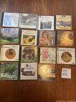Photo of 15 music CDs on wooden floor, showing world music and guitar instrumentals