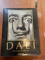 Front cover of the book with a black and white photograph of Salvador Dalí's face and his stylized mustache.