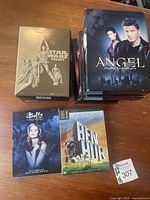Photo showing Buffy the Vampire Slayer Season 1, Angel all five seasons stacked, Star Wars trilogy gold box, and Ben Hur DVD cases together.