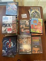 Stack of DVDs on table including The Three Stooges, Muppets from Space, Charlie Chaplin, Rowan Atkinson, and others.