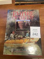 Front cover image of 'Empire of The Bay' coffee table book showing title, author, and canoe artwork.