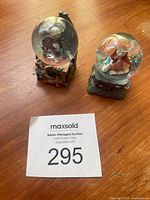 Two mini snow globes featuring characters Jack Skellington alone and Jack Skellington with Sally inside the globes with detailed bases