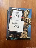 Top view of four Star Wars books stacked, with a label 'Star Wars' on top, showing part of C-3PO on hardcover book.