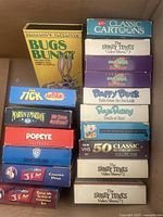Photo showing stack of classic cartoon VHS tapes including Bugs Bunny, The Tick, Arthur, Marvin Martian, Popeye, and Looney Tunes volumes
