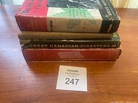 Four stacked vintage Canadian-themed books with visible wear.