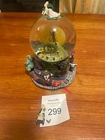 Front view of the vintage Nightmare Before Christmas snow globe showing the full base with characters and glass globe containing Jack and Sally on a curled hill with moon.