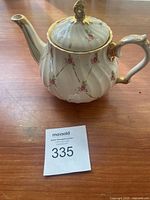 Vintage Sadler roses tea pot with pink rose pattern and gold trim on wooden tabletop.