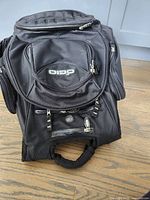Front view of black Ogio backpack with multiple zipper compartments and logo