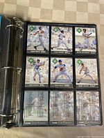 First photo of binder open to pages showing front and backs of Fleer Ultra 1991 baseball cards featuring players like Barry Bonds, Cecil Fielder, Rickey Henderson, Dave Parker, Nolan Ryan, Bob Tewksbury.