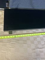 Photo showing the top surface of the black desk riser with a tape measure indicating length close to 39 inches.
