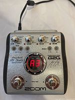 Top front view of Zoom G2G effect pedal showing control knobs, digital display, footswitches, George Lynch signature and branding.
