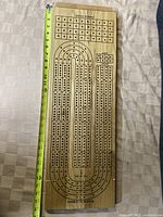 Full view of the cribbage board showing length measurement and peg holes