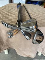 Full view of irons and 5 wood angled upright on table