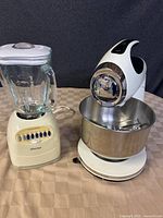 Oster blender and KitchenAid mixer side by side showing overall condition and details.