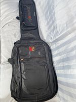 Front view of the black Crossrock soft shell guitar case showing multiple zipper pockets and the brand logo.