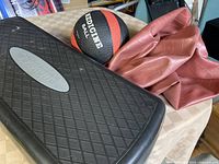 Photo showing the exercise step platform, the 8 lb medicine ball, and the deflated brown fitness ball on a table.