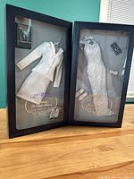 Two Diana doll clothing sets in original window box packaging showing the white skirt suit set and the white lace gown set with accessories.