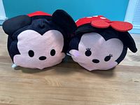 Front-facing view of two Disney Tsum Tsum plush toys portraying Mickey Mouse and Minnie Mouse, displaying faces and ears clearly.