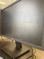 Front and side view of the Samsung 24-inch monitor with visible fingerprints on the screen and black rectangular base stand.