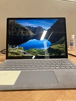 Front view with display on showing Windows 10 lock screen and keyboard