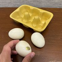 Ceramic carton top view with three alabaster eggs, sticker visible