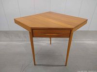 Full view of triangular corner desk showing drawer front and tapered legs