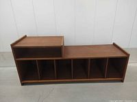 Front view showing stepped design, open shelf, six cubbies