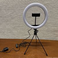 Full view of ring light on tripod with phone holder, USB cable and inline controller