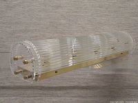 Side view showing full cylindrical glass-rod body and brass mounting bar