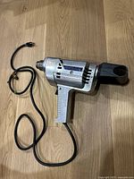 Full view of drill with cord and handle