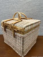 Three-quarter view of wicker picnic basket showing woven body and lid