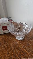 Clear glass decorative bowl next to Mikasa branded box with holiday snowflake pattern.