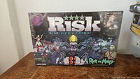 Front view of the sealed Risk: Rick and Morty Edition game showing the illustrated box art with characters from Rick and Morty.